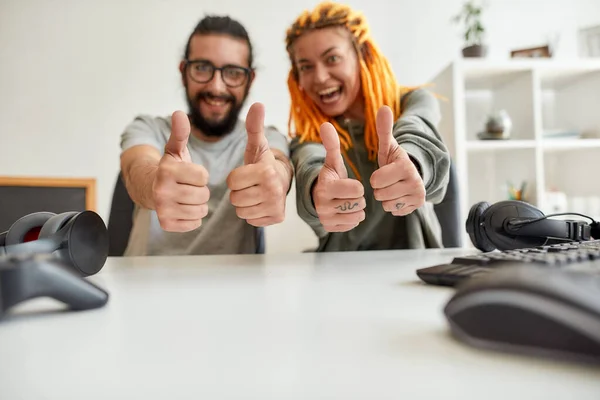 Homens e mulheres alegres a mostrarem os polegares na câmara. Jovens blogueiros de tecnologia masculina e feminina gravando vídeo blog ou vlog sobre novos gadgets em casa — Fotografia de Stock