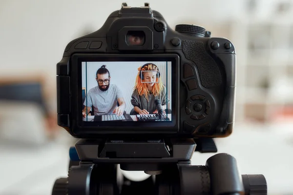 Femme aux dreadlocks chantant et jouant. Enregistrement de blogueurs féminin et masculin faisant de la musique à l'aide d'un synthétiseur, d'une batterie. Focus sur l'écran de la caméra — Photo