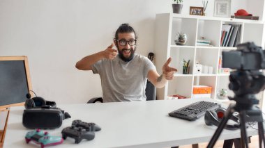 Erkek teknoloji blogcusu heyecanlı görünüyor, kamerayı işaret ediyor, video blogu veya video blogu kaydediyor.