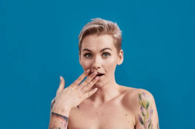 Hadi canım. Genç, çekici, yarı çıplak, mükemmel ciltli bir kadının portresi. Mavi arka planda, ağzı kapalı kameraya bakıyor.