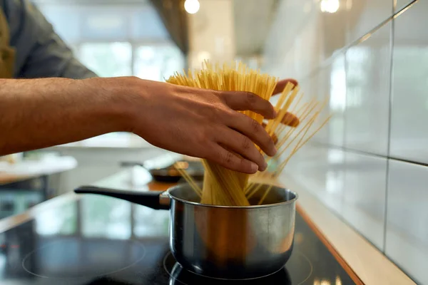 Dags för pasta. Närbild av händerna på människan, professionell kock matlagning pasta spaghetti hemma i köket. Matlagning i hemmet, italiensk matlagning — Stockfoto