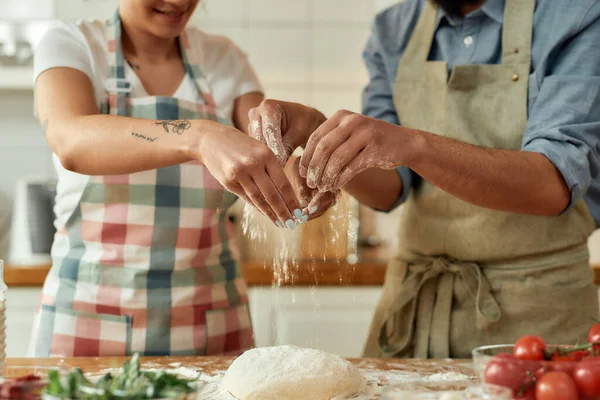 Ένα ζευγάρι να ετοιμάζει τη ζύμη μαζί. Νεαρός άντρας και γυναίκα με ποδιά μαγειρεύουν, φτιάχνουν πίτσα στο σπίτι. Χόμπι, τρόπος ζωής — Φωτογραφία Αρχείου