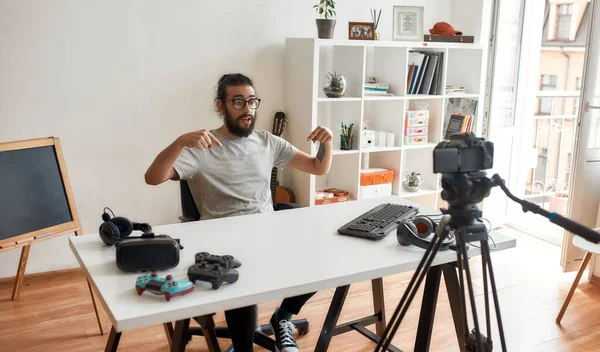남자 기술 블로거는 지지자들에게 자신의 집 스튜디오에 있는 새로운 VR 안경과 기타 가젯 들에 대해 글을 쓰고, 비디오 블로그나 vlog 를 녹음하라고 요구 한다. — 스톡 사진