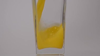 Meyve Suyu. Portakal suyunu şeffaf bir bardağa beyaz arka plana dökerken süper yavaş çekim. Kapatın. Sağlıklı içecek, vitaminler, meyve konsepti