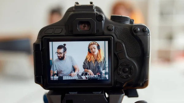 Femme aux dreadlocks chantant et jouant. Enregistrement de blogueurs féminin et masculin faisant de la musique à l'aide d'un synthétiseur, d'une batterie. Focus sur l'écran de la caméra — Photo