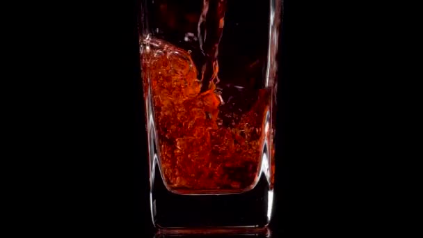 Succosa bevuta. Super slow motion shot di versare succo di melograno in un bicchiere trasparente su sfondo nero. Chiudete. Bevanda sana, vitamine, concetto di frutta — Video Stock