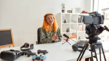 Rastalı kadın teknoloji blogcusu video günlüğü ya da vlog 'u evdeki yeni aygıtlar hakkında kaydederken konuşuyor