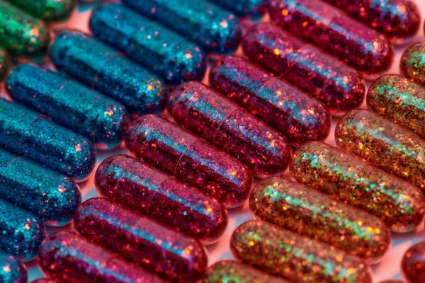 Creative concept with many colorful glitter pills lying in rows diagonally. Minimal style, art concept — Stock Photo, Image