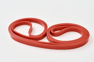 Elastik genişletici. Formda kalmak için kırmızı direnç bandı gri arkaplanda izole edildi