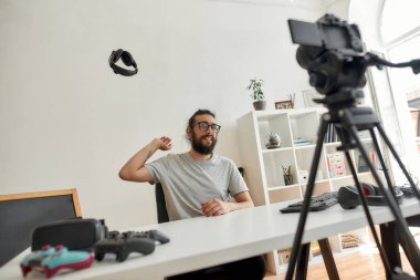 Erkek teknoloji blogcusu kulaklıkları atıyor, video blogu ya da video blogu kaydederken kalitesinden memnun değil.