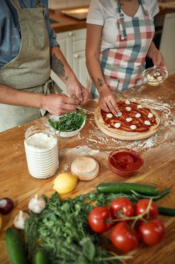 Pizza günü. Evde birlikte pizza yapan bir çiftin görüntüsü. Önlüklü adam hamura fesleğen eklerken, kadın mozzarella peyniri ekliyor. Hobi, yaşam tarzı