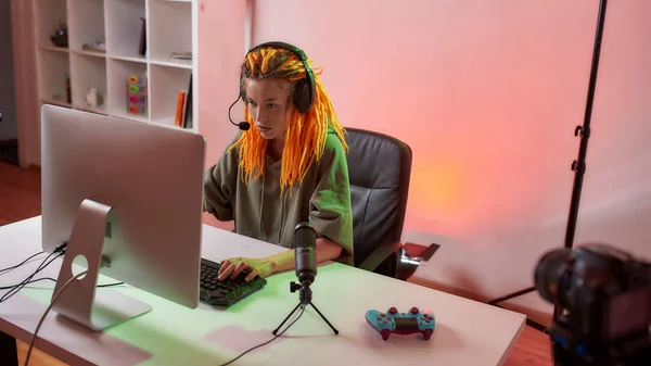 Concéntrate. Mujer gamer esport, mujer en auriculares mirando centrado, jugando videojuego en línea en el PC durante la grabación, vlog filmación en casa — Foto de Stock