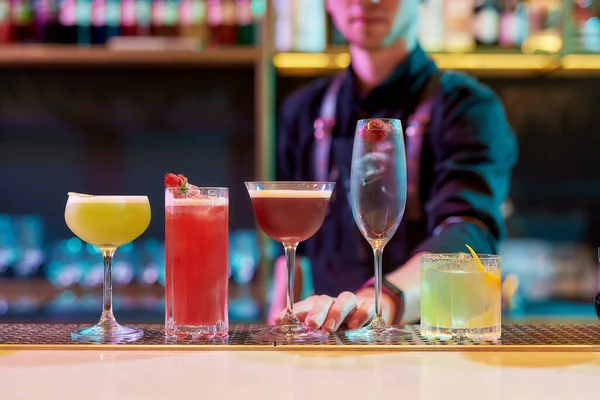 Para a vida nocturna perfeita. Coquetéis clássicos, bebida alcoólica no balcão do bar com barman profissional em pé no fundo — Fotografia de Stock