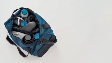 Boks malzemeleri ve aksesuarlar. Boks eldivenli spor çantasının üst görüntüsü, el kağıtları, giysiler, su şişesi ve gri arka planda izole edilmiş diğer boks malzemeleri.