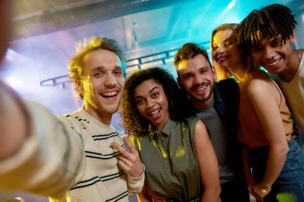 Primer plano de hombres y mujeres jóvenes sonriendo mientras tomaban selfie. Grupo multirracial de amigos pasando el rato en la fiesta en el bar — Foto de Stock