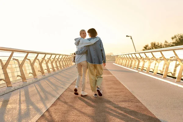 Volledige shot van lesbisch koppel knuffelen, lopen op de brug en kijken naar de zonsopgang samen. Homoseksualiteit, LGBT en liefdesconcept — Stockfoto