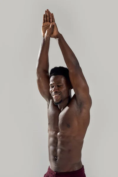 Mladý svalnatý Afroameričan s nahým trupem, s rukama nad hlavou. Záchranář se chystá potopit izolovaný přes šedé pozadí. Sport, plavání, kulturistika koncept — Stock fotografie