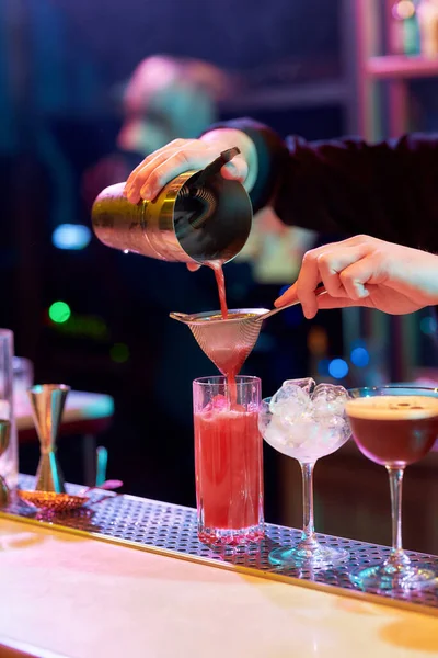 Cool Drinks. Primer plano de las manos del camarero vertiendo, mezclando ingredientes mientras hace cóctel bebida alcohólica en el mostrador del bar en el club nocturno — Foto de Stock