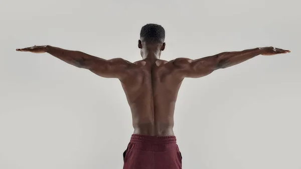 Vista posteriore dell'uomo muscoloso afroamericano con busto nudo in piedi con le braccia tese. Nuotatore in procinto di immergersi isolato su sfondo grigio. Sport, nuoto — Foto Stock