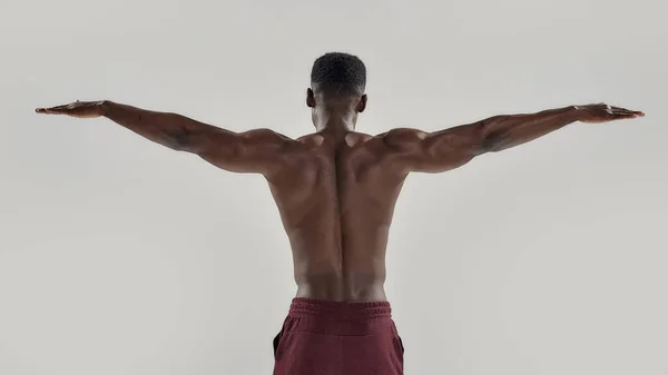 Achteraanzicht van gespierde Afro-Amerikaanse man met naakte romp staande met uitgestrekte armen. Zwemmer op het punt om te duiken geïsoleerd over grijze achtergrond. Sport, zwemmen — Stockfoto