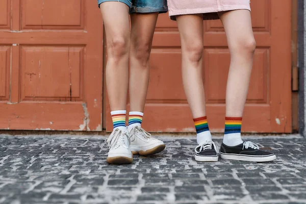 Gros plan des jambes d'un jeune couple de femmes debout ensemble devant la porte à l'extérieur — Photo