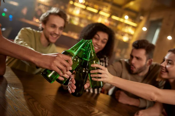 Un gruppo di amici al bar che guardano la partita sportiva in TV insieme, bevono birra, bevono bottiglie e fanno il tifo per la squadra — Foto Stock