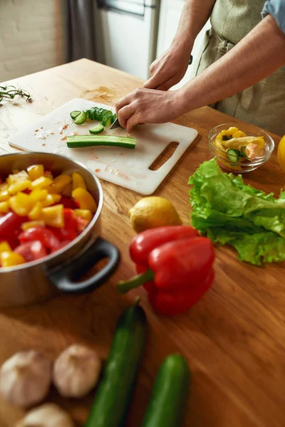 Κοντινό πλάνο των χεριών του ανθρώπου κοπή λαχανικών και βάζοντας τα σε μια κατσαρόλα, ενώ την προετοιμασία υγιεινό γεύμα, σούπα στην κουζίνα — Φωτογραφία Αρχείου