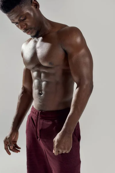 Geweldig lichaam. Gehakt schot van gespierde Afro-Amerikaanse man die zijn naakte romp laat zien terwijl hij hemdloos poseerde geïsoleerd over een grijze achtergrond. Sport, workout, bodybuilding concept — Stockfoto