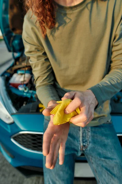 Gehakt schot van de man bestuurder vegen zijn handen af na het repareren van gebroken auto aan de kant van de weg — Stockfoto