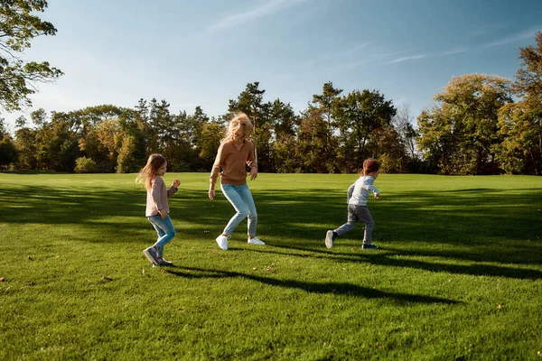 Mutluluk sağlamak. Güneşli bir günde dışarıya koşan heyecanlı bir aile. — Stok fotoğraf