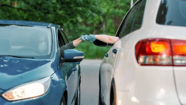 Twee automobilisten dragen beschermende handschoenen, maken vuist hobbel terwijl ze elkaar begroeten op de weg — Stockfoto