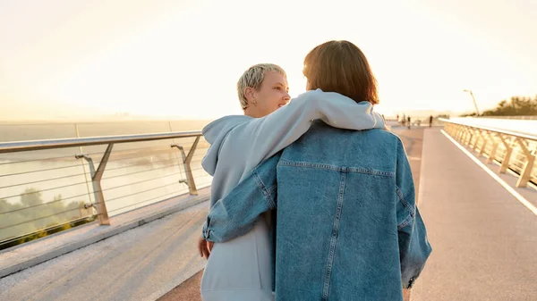 Coppia lesbica in piedi sul ponte, abbracciarsi mentre ammira l'alba insieme. Omosessualità, LGBT e concetto di amore — Foto Stock