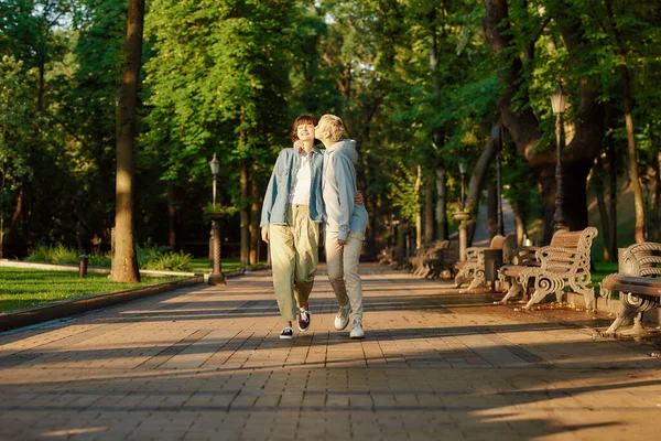 행복 한 레즈비언 커플이 시립 공원에서 데이트를 하고, 두 소녀가 함께 시간을 보내고, 야외에서 걷는 동안 키스를 하는 전체 길이 사진 — 스톡 사진