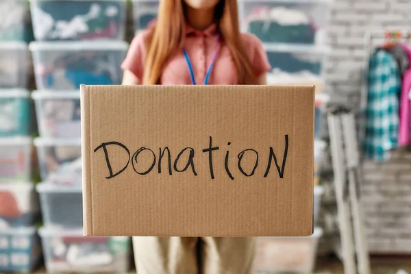 Close up della scatola per la donazione, Giovane donna volontaria in possesso di scatola di cartone mentre lavora per un ente di beneficenza — Foto Stock