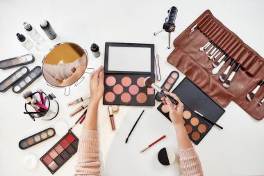 Makyaj ilhamı. Genç bir kadın, makyaj yapan bir sanatçı, masada oturuyor. Makyaj yapan yakın plan kadın elleri. Kozmetik reklam konsepti