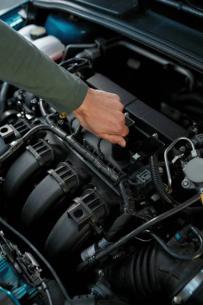 Primer plano de la mano del hombre comprobando el motor de un coche roto —  Fotos de Stock