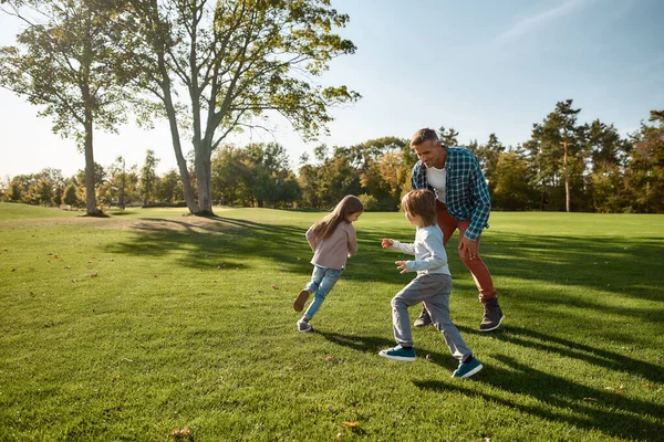 Soutenir la croissance émotionnelle et physique de vos enfants. Famille excitée courir à l'extérieur par une journée ensoleillée — Photo