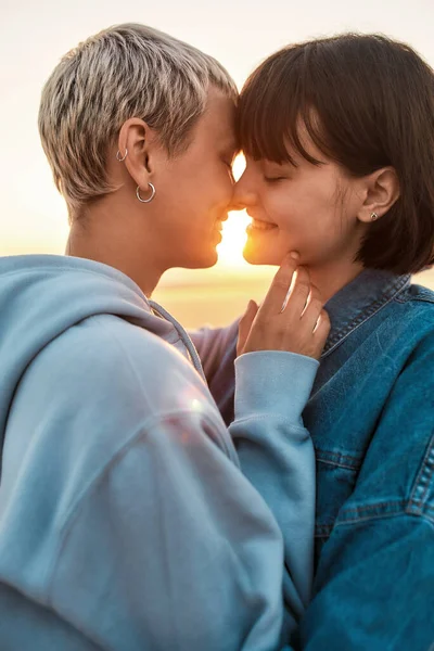 Young lesbian couple having romantic moment, Two women going to kiss while watching the sunrise together — Stock Photo, Image