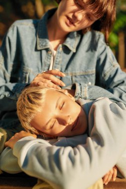 Uyum. Güneşli bir günde parkta bankta dinlenen iki genç kadının görüntüsü. Lezbiyen çift dışarıda birlikte vakit geçiriyor.