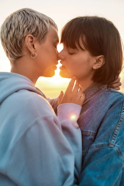 젊은 레즈비언 커플은 낭만적 인 순간을 보내고, 두 여성은 함께 일출을 보면서 키스를 하고, 선택에 초점을 맞춥니다. — 스톡 사진