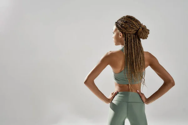 Perfekter Körper. Rückenansicht eines jungen athletischen Mixed Race Fitness-Modells in Sportbekleidung, das im Studio posiert, isoliert über grauem Hintergrund — Stockfoto