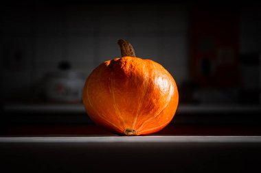 Masanın üzerinde duran turuncu balkabağı. Balkabağı Cadılar Bayramı için kesmeye hazır.. 