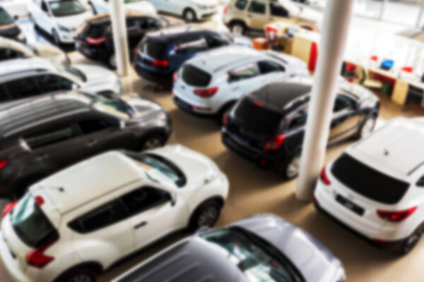 Новые автомобили в автосалоне размыты
