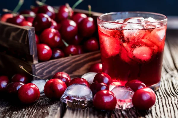 Fresh cherries in a wooden box, ice, cherry juice — Stock Photo, Image