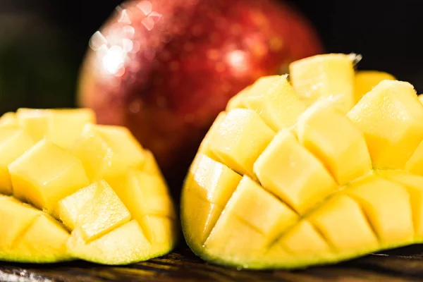 Hela och skär mango på en mörk trä bakgrund — Stockfoto