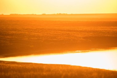 Alan ve göl üzerinde güzel gün batımı