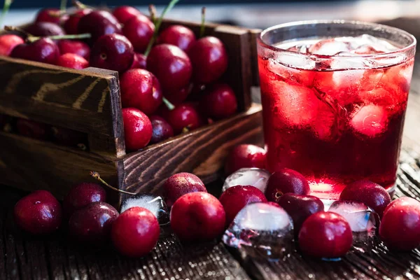 Cerezas frescas en una caja de madera, hielo, jugo de cereza —  Fotos de Stock