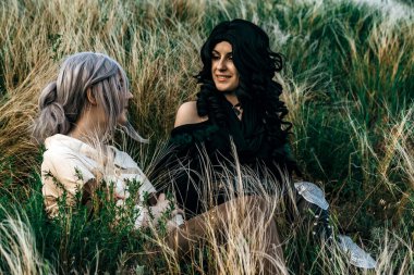 Fantezi cosplay iki güzel oturup birlikte çim