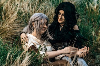 Fantezi cosplay iki güzel oturup birlikte çim