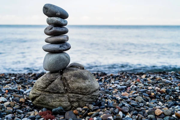 Stone tower of pebbles on sea shore — Stock Photo, Image